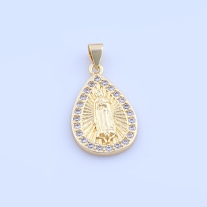 May include: Gold-colored pendant in a teardrop shape. The pendant features an engraved image of a religious figure surrounded by a halo design. The outer edge is lined with small, clear gemstones. A small loop is at the top for a chain.