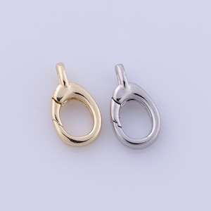 May include: Two oval-shaped clasps for jewellery making. One is gold and the other is silver.