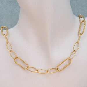 May include: A gold chain necklace with alternating oval and twisted oval links.