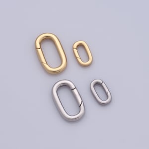 May include: Three oval-shaped metal clasps in different sizes. The largest clasp is gold, and the two smaller clasps are silver.