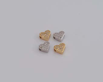 May include: Four heart-shaped beads, two in gold and two in silver, each encrusted with small, clear crystals. The beads have a hole for stringing. Ideal for jewelry making or crafting projects.