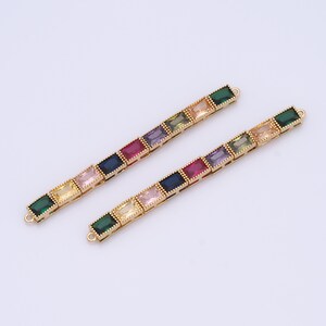 May include: Two gold chains with colorful square-shaped gemstones. The chains are made of gold metal and have a delicate design.