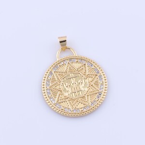 May include: Gold pendant with a starburst design and clear rhinestones around the edge. The pendant features a geometric pattern in the center.