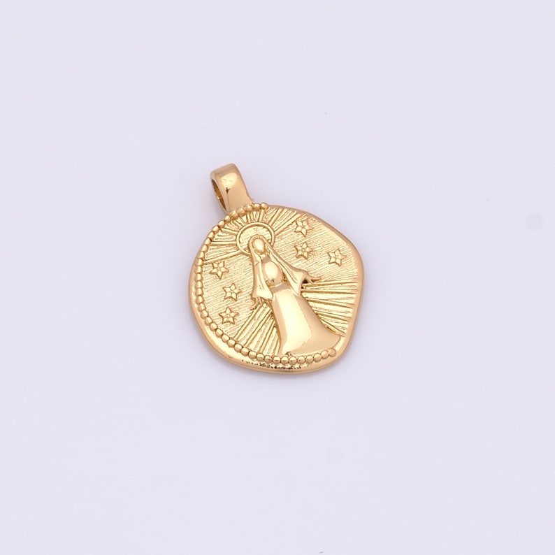 K&ouml;nnte beinhalten: Goldfarbener Anh&auml;nger mit einem erhabenen Bild einer Frau mit Heiligenschein und Sternen um sie herum. Der Anh&auml;nger ist rund und hat eine strukturierte Oberfl&auml;che.