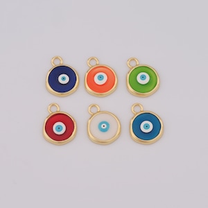 Könnte beinhalten: Sechs goldfarbene Charms mit einem blauen bösen Auge. Die Charms sind rund und haben eine glatte, glänzende Oberfläche. Die bösen Augen sind von einem weißen Kreis umgeben und haben eine blaue Pupille.