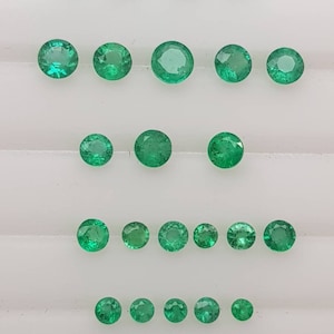 Op de afbeelding: Assortiment van ronde, groene smaragden in verschillende maten. De smaragden zijn gerangschikt in rijen, met de grootste smaragden bovenaan en de kleinste smaragden onderaan.