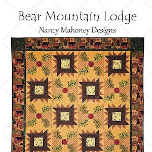 May include: A quilt pattern featuring a brown and tan bear mountain lodge design with a green and brown border. The quilt is 60 1/2 inches by 72 1/2 inches.