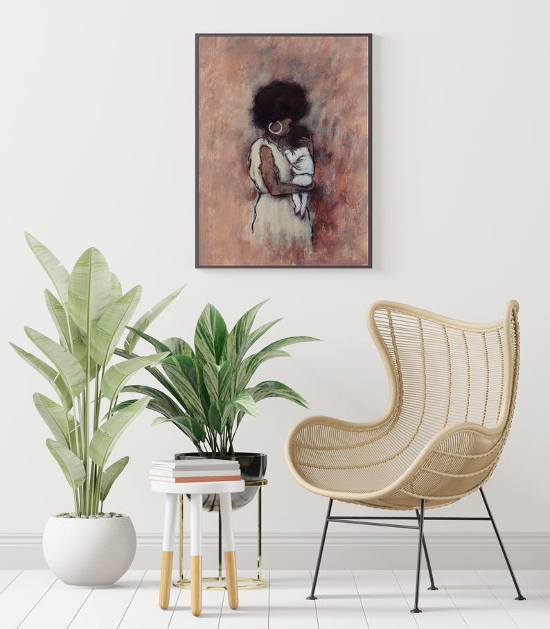 May include: An art print depicting a woman and child in a soft, muted colour palette of browns and creams. The framed artwork hangs on a white wall, complemented by potted plants, a small side table, and a woven chair. The overall aesthetic is calm and inviting.