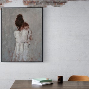 May include: A framed painting of a woman holding a child in her arms. The woman is wearing a white dress and the child is wearing a white onesie. The painting is set against a light gray background.