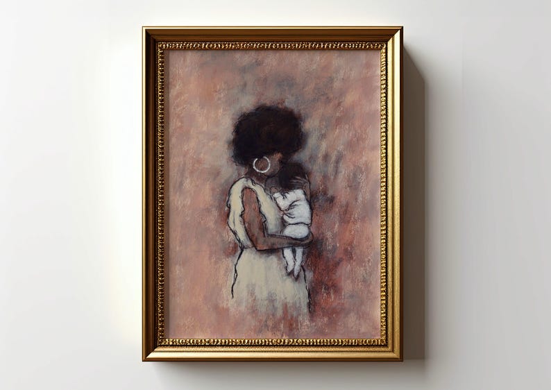May include: A framed art print shows a mother and child. The artwork features a woman with dark hair and hoop earrings, wearing a cream dress. The background is a blend of pink and brown hues. The frame is gold-colored.