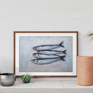 K&ouml;nnte beinhalten: Ein gerahmtes Gem&auml;lde von f&uuml;nf silbernen Fischen auf hellem grauen Hintergrund. Die Fische sind in einer Reihe angeordnet, mit den Schw&auml;nzen nach rechts zeigend. Das Gem&auml;lde ist in einem braunen Holzrahmen.