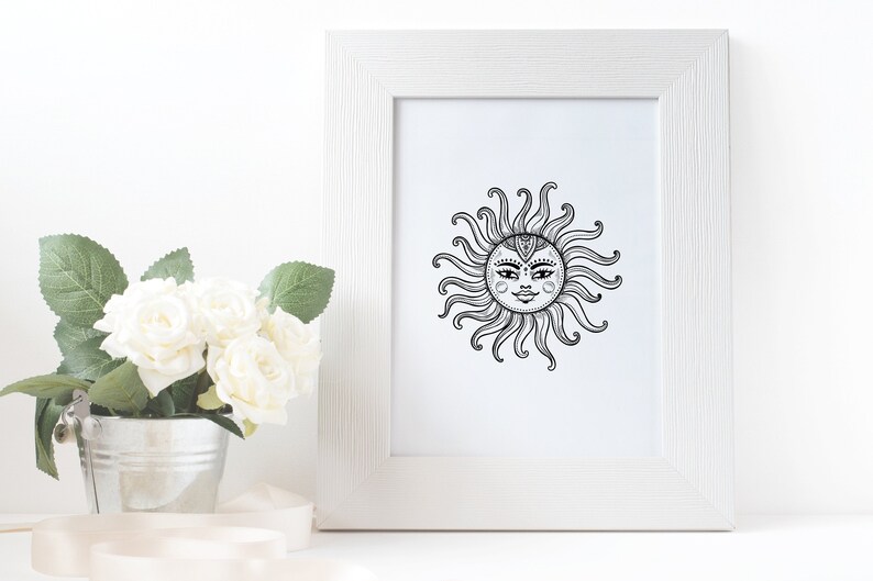 May include: A black and white line drawing of a sun with a face inside. The sun is framed in a white frame.