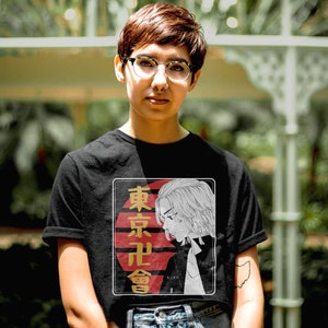 May include: A black t-shirt with a graphic print of a character from a Japanese anime. The graphic features a red and white sun with the text "東京卍會" in gold lettering.