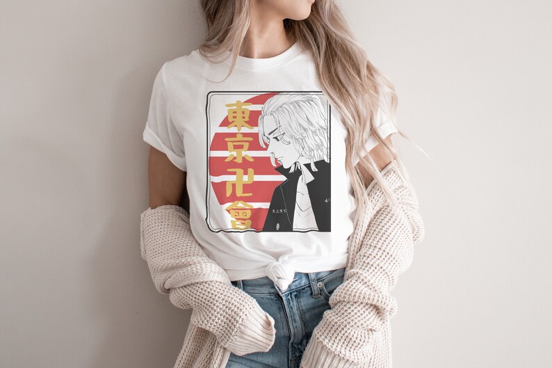 May include: White t-shirt with a graphic print of a cartoon character with blonde hair. The graphic also includes Japanese text and a red and white sun design.