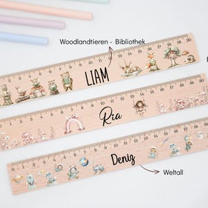 May include: Three light-coloured wooden rulers, each 20 cm long, featuring printed illustrations and names. The top ruler shows woodland animals and the name LIAM. The middle ruler displays floral fairy motifs and the name Ria. The bottom ruler features space-themed graphics and the name Deniz.