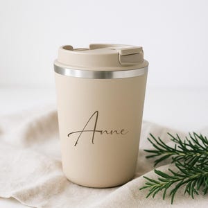 Personalisierte Kaffeebecher aus Edelstahl als Weihnachtsgeschenk. Drei elegante Farben – Beige, Weiß und Schwarz – mit individueller Gravur deines Namens. Doppelwandig isoliert, BPA-freier Deckel, ideal für Kaffee oder Tee. Perfekt als Geschenk für Mama, Papa, Kollegen oder Freunde zu Weihnachten. Stilvoller To-Go-Becher von Geschenkewerk.