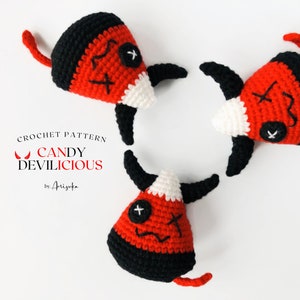 Pode incluir: Três personagens de milho doce de crochê com chifres de diabo e um rosto costurado. Os personagens são vermelhos, brancos e pretos. O texto "CROCHET PATTERN CANDY DEVILICIOUS by Arisuka" está abaixo dos personagens.