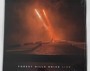 May include: A vinyl record cover with a dark background and two spotlights shining down on a stage. The text "FOREST HILLS DRIVE LIVE" is printed in white on the bottom of the cover.