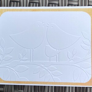 Tarjeta con una familia de pájaros felices en relieve para un amigo. Tarjeta en blanco con sobre kraft. Pájaros en una tarjeta. Diseño en relieve. Tarjetas de notas.