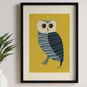 May include: Framed art print featuring a stylized owl illustration. The owl has a white head, large black eyes, and a blue and white striped body, set against a mustard yellow background. The artwork is enclosed in a black frame.