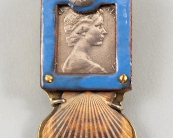 May include: A vintage coin with a woman's profile is framed in blue enamel and brass, with a red carnelian stone and a brass gear on top. A seashell is attached to the bottom.