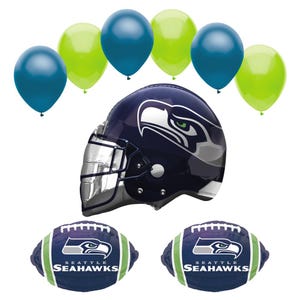 May include: A collection of Seattle Seahawks themed party decorations. Includes a navy blue and silver football helmet, two footballs, and several blue and green balloons. The footballs and helmet feature the Seahawks logo.