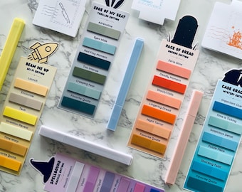 May include: A collection of colorful sticky note sets with coordinating highlighters. The sets are themed with titles like "Edge of My Seat," "Page of Dread," and "Beam Me Up." Each set features a variety of colors and text labels.