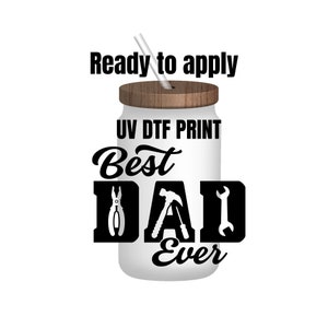 May include: White tumbler with a brown lid and a straw. The tumbler has the text "UV DTF PRINT Best Dad Ever" with tool graphics.