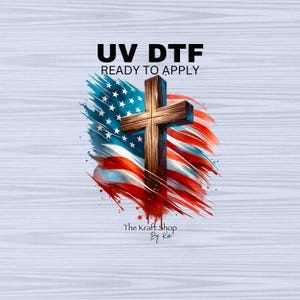 May include: A wooden cross superimposed over a watercolor American flag design. The image includes the text "UV DTF READY TO APPLY" and the shop name "The Kraft Shop By Kat". The flag features red and white stripes with blue stars.