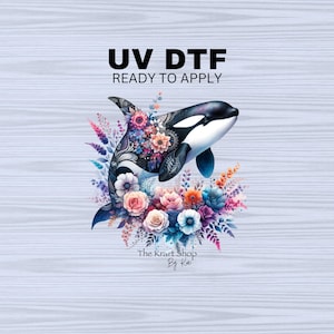 May include: A black and white orca whale with a floral design, surrounded by colorful flowers. The text "UV DTF READY TO APPLY" is above the orca. The text "The Krarft Shop By Kai" is below the orca.