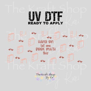 May include: A light gray background with a design featuring books and hearts. The text "UV DTF READY TO APPLY" is at the top. The phrase "HANG ON let me BOOK MATH this" is in the center. The Kraft Shop logo is at the bottom.