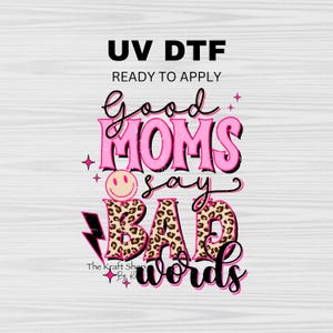 May include: Pink and black graphic design with the text "Good Moms Say Bad Words" with a smiley face and leopard print. The text "UV DTF Ready to Apply" is at the top of the design.