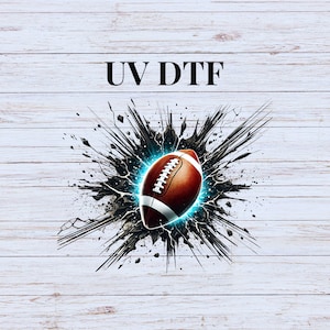 May include: A digital graphic of a brown and white football with a glowing blue outline, set against a black explosion effect. The text "UV DTF" is above the football on a white wood grain background.
