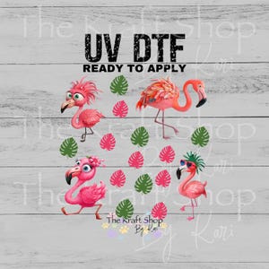May include: UV DTF transfer featuring four cartoon flamingos in various poses, surrounded by pink and green tropical leaves. The text "UV DTF READY TO APPLY" is displayed at the top. The Kraft Shop By Kari logo is at the bottom.