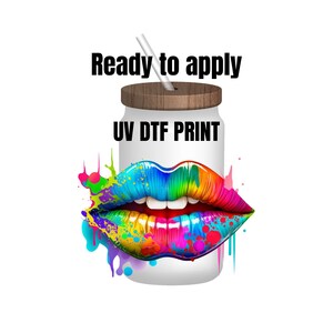 May include: A white tumbler with a wooden lid and a straw. The tumbler has a colorful rainbow lips design and the text "UV DTF PRINT" on the front. The text "Ready to apply" is above the tumbler.