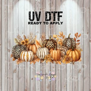 May include: A fall-themed design featuring a collection of pumpkins with various patterns and colors, including leopard print and striped pumpkins. The design includes the text "UV DTF READY TO APPLY" and is set against a wooden background.