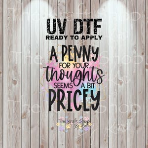 May include: UV DTF ready to apply graphic with the text "A penny for your thoughts seems a bit pricey" in black. The design includes colorful watercolor accents and a gold geometric frame, set against a wood-grain background.