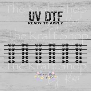 May include: A black UV DTF transfer sheet with paw prints arranged in rows. The text "UV DTF READY TO APPLY" is at the top. The Kraft Shop By Kari logo is at the bottom.