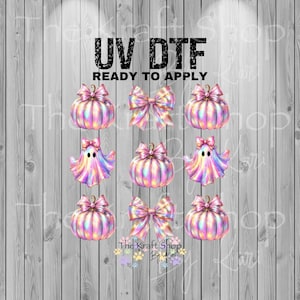 May include: UV DTF ready to apply sheet featuring colorful pumpkins, bows, and ghosts. The pumpkins and ghosts have a shimmering, iridescent effect. The bows are pink. The background is a gray and white wood grain.