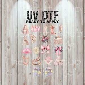 May include: UV DTF ready to apply transfers featuring various pink and gold decorative elements. The image includes a stack of gift boxes, perfume bottles, a stocking, a boot, an angel, a bow, and a harp. The Kraft Shop By Lea logo is at the bottom.