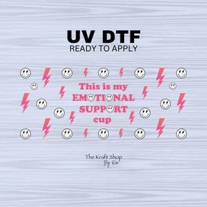 May include: UV DTF ready to apply transfer with a design featuring smiley faces, pink lightning bolts, and the text "This is my EMOTIONAL SUPPORT cup". The Kraft Shop by Kai.