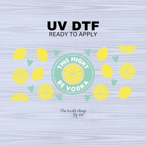 May include: A light blue circle with the text "This Might Be Vodka" in white. The circle is surrounded by yellow lemons and green hearts on a light gray wood background. The text "UV DTF Ready to Apply" is at the top of the image. The text "The Kraft Shop By Kai" is at the bottom of the image.