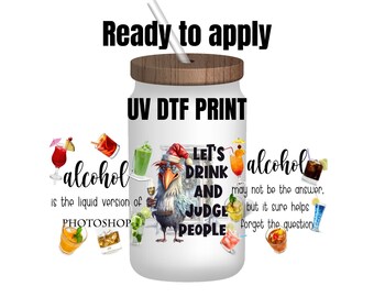 May include: White tumbler with a wood lid and a straw. The tumbler has a colorful graphic with the text "Let's Drink and Judge People" and "Alcohol may not be the answer, but it sure helps forget the question".