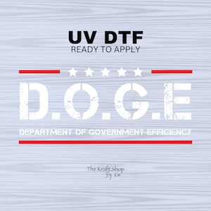 May include: White text on a red and white background reads "D.O.G.E. DEPARTMENT OF GOVERNMENT EFFICIENCY". Above the text is "UV DTF READY TO APPLY" in black text. Below the text is "The Kraft Shop By K" in black text.