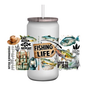 May include: White tumbler with a wood lid and a straw. The tumbler is decorated with fishing-themed images, including fish, fishing rods, a fishing net, a lantern, a backpack, and a sign that says "Fishing Life". There are also several text phrases on the tumbler, including "Eat. Sleep. Fish. Repeat", "Just one more cast", and "Born to Fish".