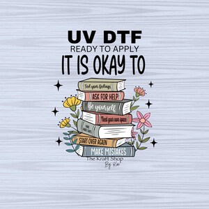 May include: A stack of books with inspirational quotes on each book, including "Feel your feelings", "Ask for help", "Be yourself", "Need your own space", "Start over again", and "Make mistakes". The books are surrounded by flowers and stars. The text "UV DTF Ready to Apply It is Okay To" is at the top of the image. The text "The Kraft Shop By Ka" is at the bottom of the image.