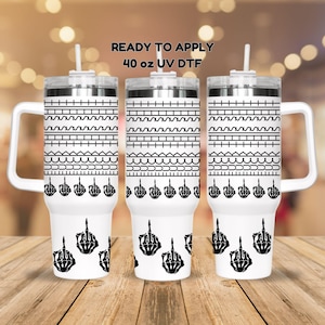 May include: Three white 40 ounce stainless steel tumblers with black skeleton middle finger designs and a wavy line pattern. The text "READY TO APPLY 40 oz UV DTF" is printed on the top of the image.