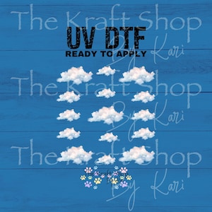 May include: A sheet of UV DTF ready to apply transfers featuring multiple white fluffy cloud designs arranged in a grid pattern, with the text UV DTF READY TO APPLY at the top and a small collection of colorful paw prints at the bottom.