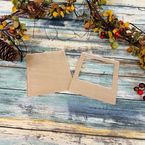 May include: Two brown cardboard picture frames on a rustic wooden background. The frames are blank and ready for photos or artwork.