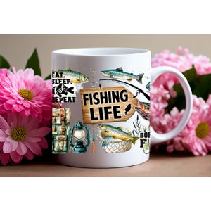 May include: White ceramic mug with a fishing theme. The mug features a brown wooden sign with the text "Fishing Life" and illustrations of fish, fishing gear, and a lantern. The text "Eat. Sleep. Fish. Repeat" is printed on the left side of the mug.